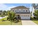 Charming two-story home with a gray exterior, a two-car garage, and a beautifully landscaped front yard at 408 Torwood Cir, Apex, NC 27523