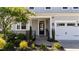 Inviting front porch with brick accents and landscaping, complemented by a well-maintained two-car garage at 408 Torwood Cir, Apex, NC 27523