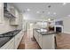 Open kitchen view with an island, stainless steel appliances, and fireplace in the background at 408 Torwood Cir, Apex, NC 27523