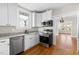 Updated kitchen features stainless appliances, granite countertops, and white cabinets at 409 N Hyde Park Ave, Durham, NC 27703