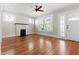 Bright living room featuring a decorative fireplace, hardwood floors, and large windows at 409 N Hyde Park Ave, Durham, NC 27703