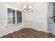 Dining room featuring wainscoting detail, wood floors, and a large window overlooking the front yard at 41 Tan Oak Dr, Selma, NC 27576