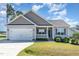Single-Gathering home with a two-car garage, landscaped lawn, and covered front porch at 41 Tan Oak Dr, Selma, NC 27576