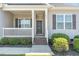 Covered front porch features a traditional-style entrance, gray siding, and white railing at 41 Tan Oak Dr, Selma, NC 27576