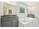 This bathroom has a tub, double vanity, granite countertop, a mirror, and a window at 421 Gilpin Way, Cary, NC 27519