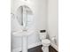 Bathroom featuring a pedestal sink, round mirror, toilet, and dark hardwood flooring at 421 Gilpin Way, Cary, NC 27519