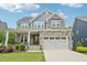 Charming two-story home featuring stone and siding accents, a two-car garage, and a welcoming front porch at 421 Gilpin Way, Cary, NC 27519