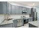 Kitchen featuring grey cabinetry, stainless steel appliances, and granite countertops at 421 Gilpin Way, Cary, NC 27519