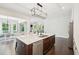 Open kitchen with a large island, stainless steel dishwasher, hardwood floors, and seamless flow to the dining area at 421 Gilpin Way, Cary, NC 27519