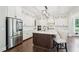 Gourmet kitchen with stainless steel appliances, white cabinets, island, and hardwood floors for a modern look at 421 Gilpin Way, Cary, NC 27519