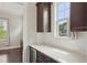 Wet bar featuring a beverage cooler, granite countertop, stylish cabinetry, and view of the well-manicured lawn at 421 Gilpin Way, Cary, NC 27519