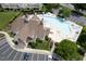 Aerial view of the community clubhouse with a resort-style pool, ample parking, and lush greenery at 5113 Lady Of The Lake Dr, Raleigh, NC 27612