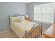 Cozy bedroom with yellow patterned bedding, window with blinds, and neutral-toned walls at 5113 Lady Of The Lake Dr, Raleigh, NC 27612