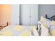 Comfortable bedroom featuring yellow patterned bedding and a view of double closets at 5113 Lady Of The Lake Dr, Raleigh, NC 27612
