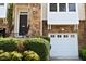 Charming townhouse exterior with stone accents, a black door, and a white garage door at 5113 Lady Of The Lake Dr, Raleigh, NC 27612