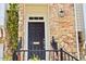 Inviting front door with stone surround, black railings, and classic exterior lighting at 5113 Lady Of The Lake Dr, Raleigh, NC 27612