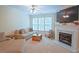 Bright living room features a cozy fireplace, neutral tones, and large windows offering natural light at 5113 Lady Of The Lake Dr, Raleigh, NC 27612
