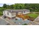Aerial view of the home with a wooden deck, gravel area, and fenced yard at 5200 Mrs Fuller Rd, Mebane, NC 27302