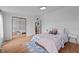Bedroom with wood floors, closet with mirrors, and an open door to the hall at 5200 Mrs Fuller Rd, Mebane, NC 27302
