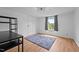 Large bedroom features wood-look flooring, a closet, and a bright window for an open and airy feel at 5200 Mrs Fuller Rd, Mebane, NC 27302