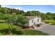 Home exterior view with stone accents, lush lawn, gravel walkway, and an inviting backyard at 5200 Mrs Fuller Rd, Mebane, NC 27302