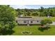 A front yard with flower bed leading up to a one story home with mature trees and partial lake view at 5200 Mrs Fuller Rd, Mebane, NC 27302