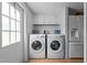 Functional laundry area with washer, dryer, built-in cabinets, and modern appliances at 5200 Mrs Fuller Rd, Mebane, NC 27302