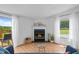 Living room featuring a fireplace, large windows, and a sliding door to the deck at 5200 Mrs Fuller Rd, Mebane, NC 27302