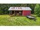 Shot of a storage outbuilding with lawn equipment and a trailer parked outside at 5200 Mrs Fuller Rd, Mebane, NC 27302