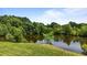 Tranquil pond surrounded by vibrant green foliage and mature trees reflecting in the water at 5200 Mrs Fuller Rd, Mebane, NC 27302
