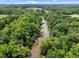 An aerial view of a serene river winding through lush green trees with a clear blue sky overhead at 5942 Big Nance Dr, Raleigh, NC 27616