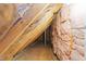 Unfinished attic space featuring visible wooden beams, metal supports, and pink insulation at 5942 Big Nance Dr, Raleigh, NC 27616