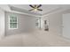 Large bedroom with neutral walls, plush carpeting, windows, and a ceiling fan at 5942 Big Nance Dr, Raleigh, NC 27616