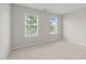 Bedroom with neutral walls, carpet flooring, and two windows at 5942 Big Nance Dr, Raleigh, NC 27616