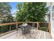 Deck with an outdoor dining set, a brown wood railing and partial shade from an overhead tree at 5942 Big Nance Dr, Raleigh, NC 27616