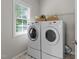 Bright laundry room equipped with modern washer and dryer and a window at 5942 Big Nance Dr, Raleigh, NC 27616