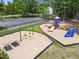 Community playground featuring swings, slides, and climbing equipment with a parking area nearby at 5942 Big Nance Dr, Raleigh, NC 27616