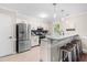Bright kitchen with white cabinetry, stainless steel appliances, and granite counters with bar stool seating at 6104 New Market Way, Raleigh, NC 27609