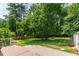 Landscaped backyard with green grass, mature trees, and a custom playhouse at 7009 Brecken Ridge Ave, Raleigh, NC 27615