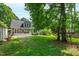 Spacious backyard featuring a well-manicured lawn, lovely deck, and a charming treehouse for outdoor enjoyment at 7009 Brecken Ridge Ave, Raleigh, NC 27615