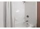 Clean white tiled bathtub and shower with a rainfall showerhead for a relaxing bathing experience at 7009 Brecken Ridge Ave, Raleigh, NC 27615