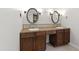 Bathroom vanity with double sinks, oval mirrors, and sconce lighting creates a bright and functional space at 7009 Brecken Ridge Ave, Raleigh, NC 27615