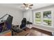 Bright bedroom with a ceiling fan, hardwood flooring, and large windows offering views of the neighborhood at 7009 Brecken Ridge Ave, Raleigh, NC 27615