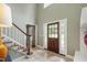 Warm entryway with a wooden front door, staircase, tile flooring, and neutral wall color at 7009 Brecken Ridge Ave, Raleigh, NC 27615