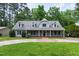 Charming gray two-story home featuring a welcoming front porch and well-manicured lawn at 7009 Brecken Ridge Ave, Raleigh, NC 27615