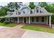 Inviting home exterior with a wide front porch, complemented by lush greenery and mature trees at 7009 Brecken Ridge Ave, Raleigh, NC 27615