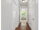 Hallway features hardwood floors and leads to bathroom, showcasing a soaking tub with bright natural light at 7009 Brecken Ridge Ave, Raleigh, NC 27615