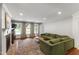 Bright living room featuring a brick fireplace, hardwood floors, and a comfortable green sofa at 7009 Brecken Ridge Ave, Raleigh, NC 27615
