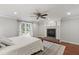 Comfortable main bedroom with a fireplace and large windows allowing for plenty of natural light at 7009 Brecken Ridge Ave, Raleigh, NC 27615