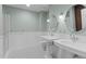 Bright bathroom featuring dual sinks, round mirrors, a glass shower, and sleek white tiling with black accent floor at 710 Independence Pl # 301, Raleigh, NC 27603